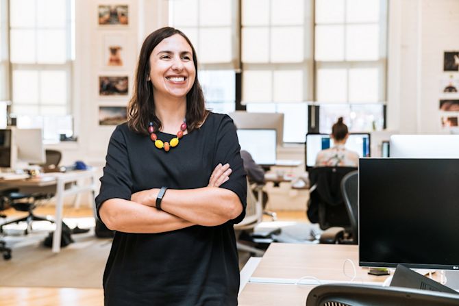 Woman smiling in office 5 Online Reputation Management Strategies to Drive Brand Trust