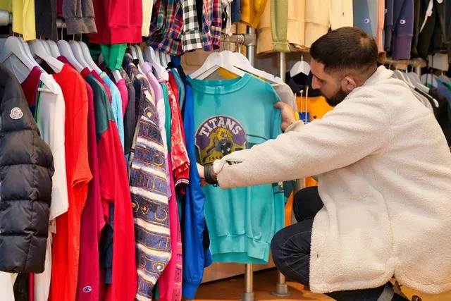 A man looking at clothes in a store How to save while holiday shopping