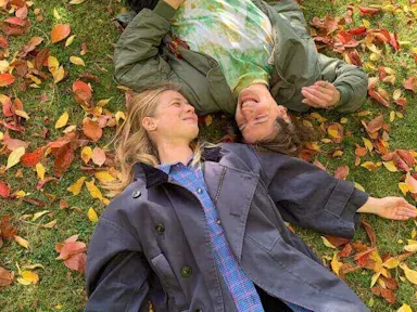 Two people lying on the grass in a garden Garden ideas