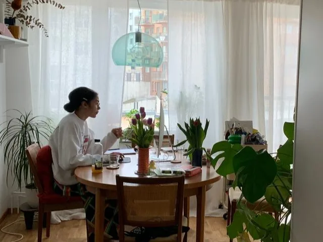 a woman sitting at a table in an apartment insurance money moments
