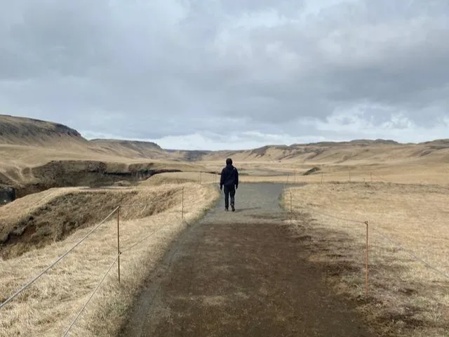 A person in the distance walking a long a road Your road trip checklist for a safe and memorable getaway
