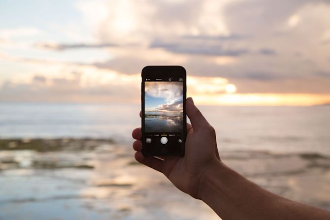 View through the camera lens of a mobile phone Mobile phone taking a picture of the sea
