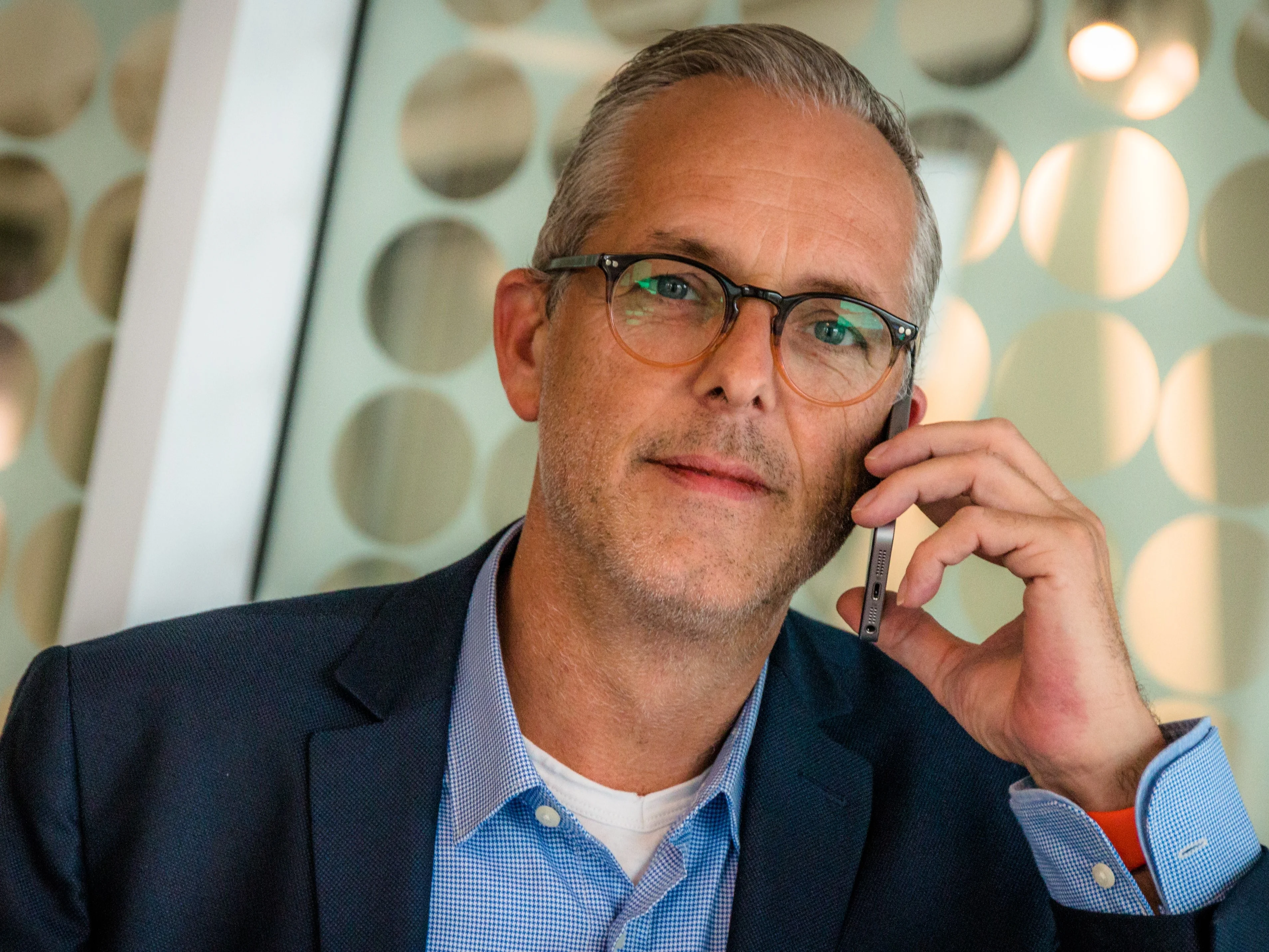 Man in casual business attire talking on a smartphone How to identify a scammer over the phone