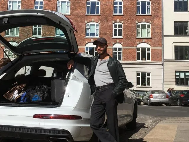 A man standing next to a car full of luggage Renter's insurance guide