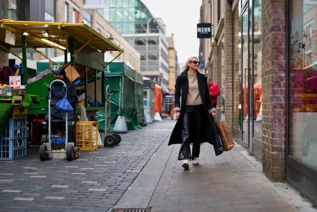 a woman walking along a street with a shopping bag creative holiday gifts