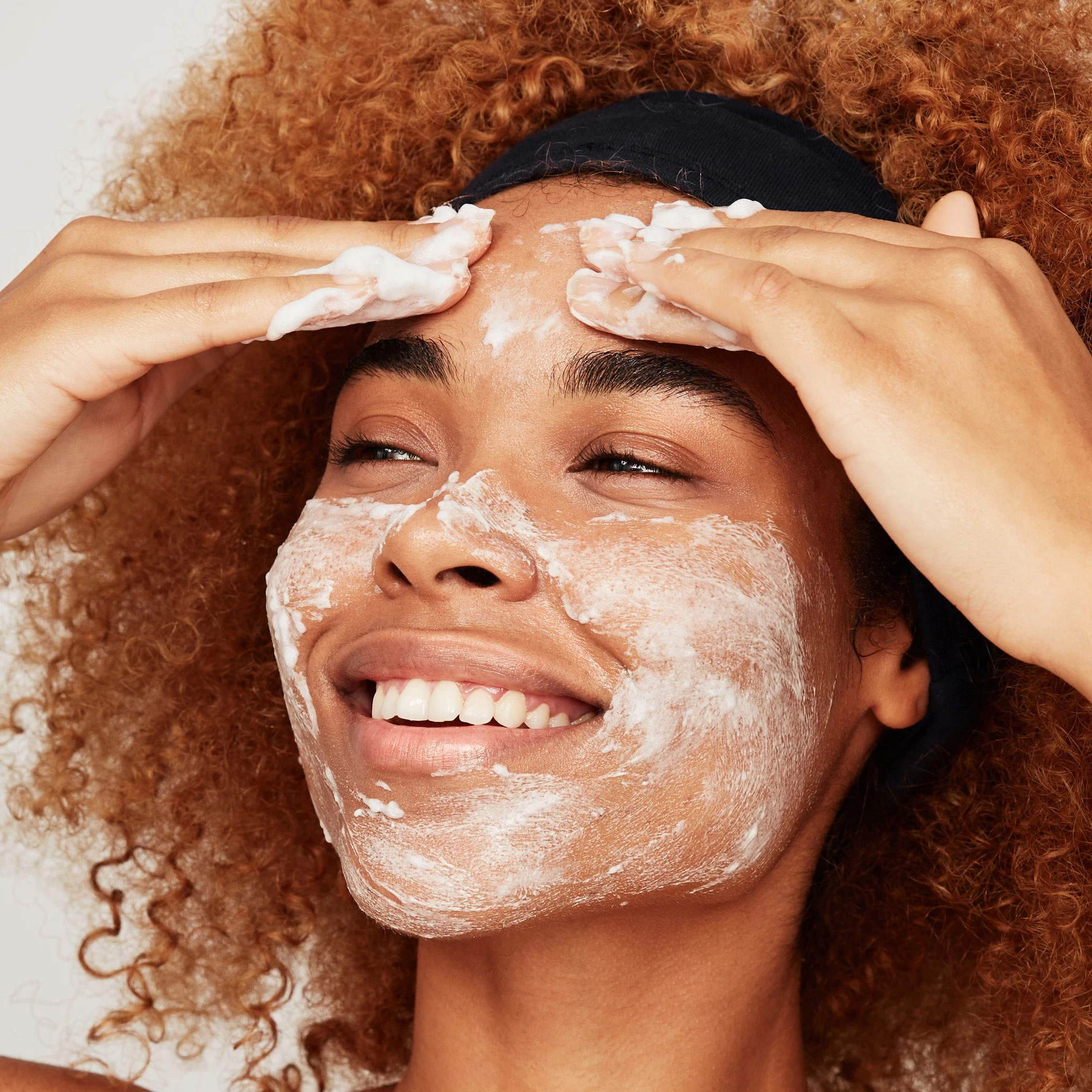Woman applying white facial lotion