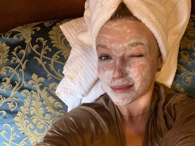 A woman taking a selfie with her hair in a towel How to tell if a beauty product is vegan