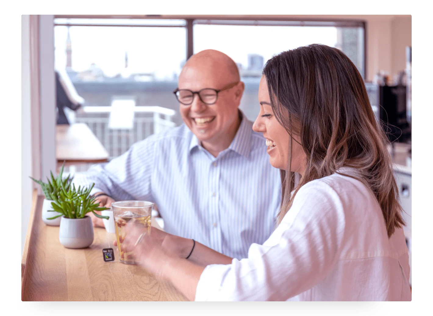 Photo of Trustpilot employees sitting and talking in the office's kitchen