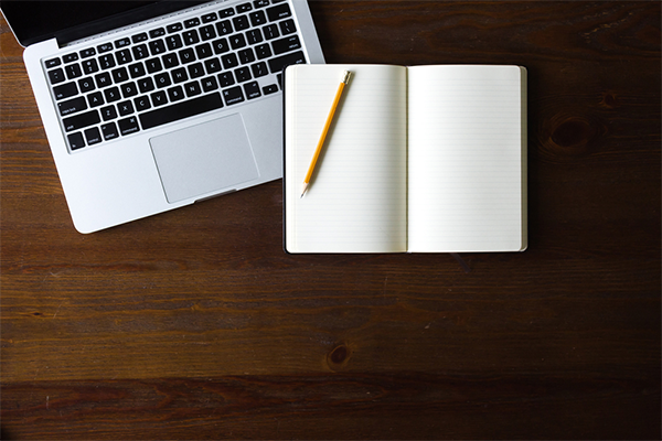 Laptop and empty notebook with a pencil