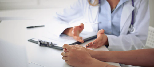 Doctor sitting at a desk with a clipboard