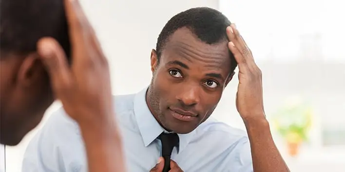 Man looking in mirror and touching hair
