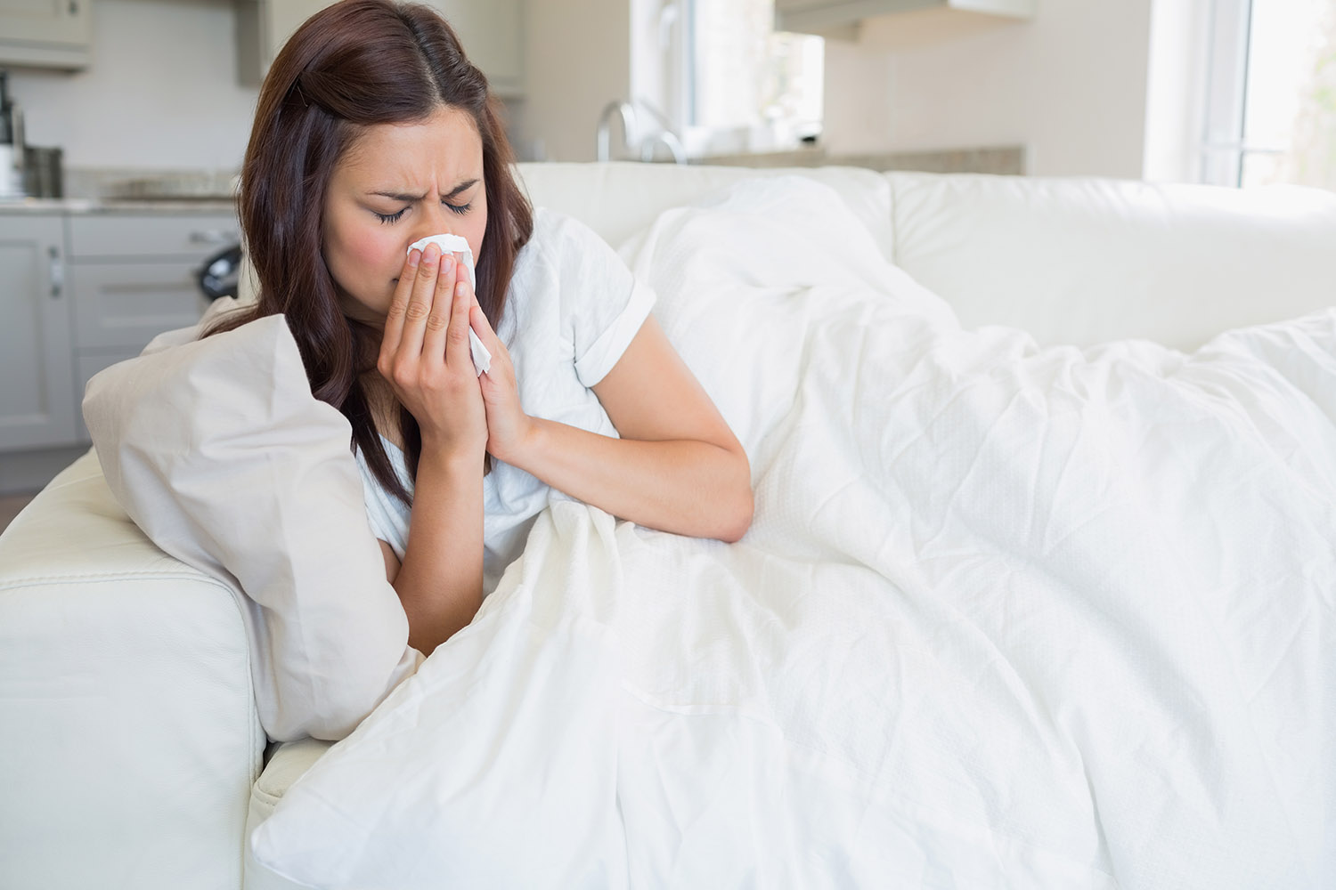 woman lying down blowing nose