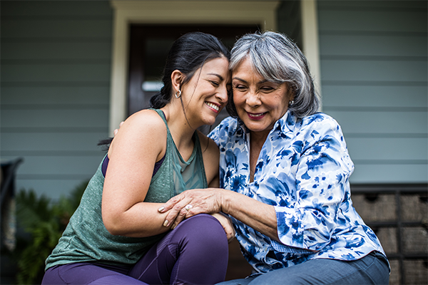 Two women of different ages smiling and hugging