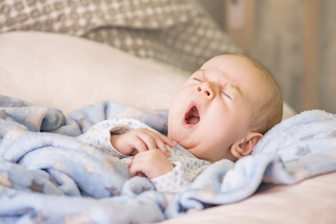 Baby yawning in blanket