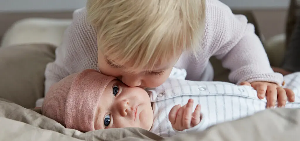 Johnson's Baby sibling kissing sister image