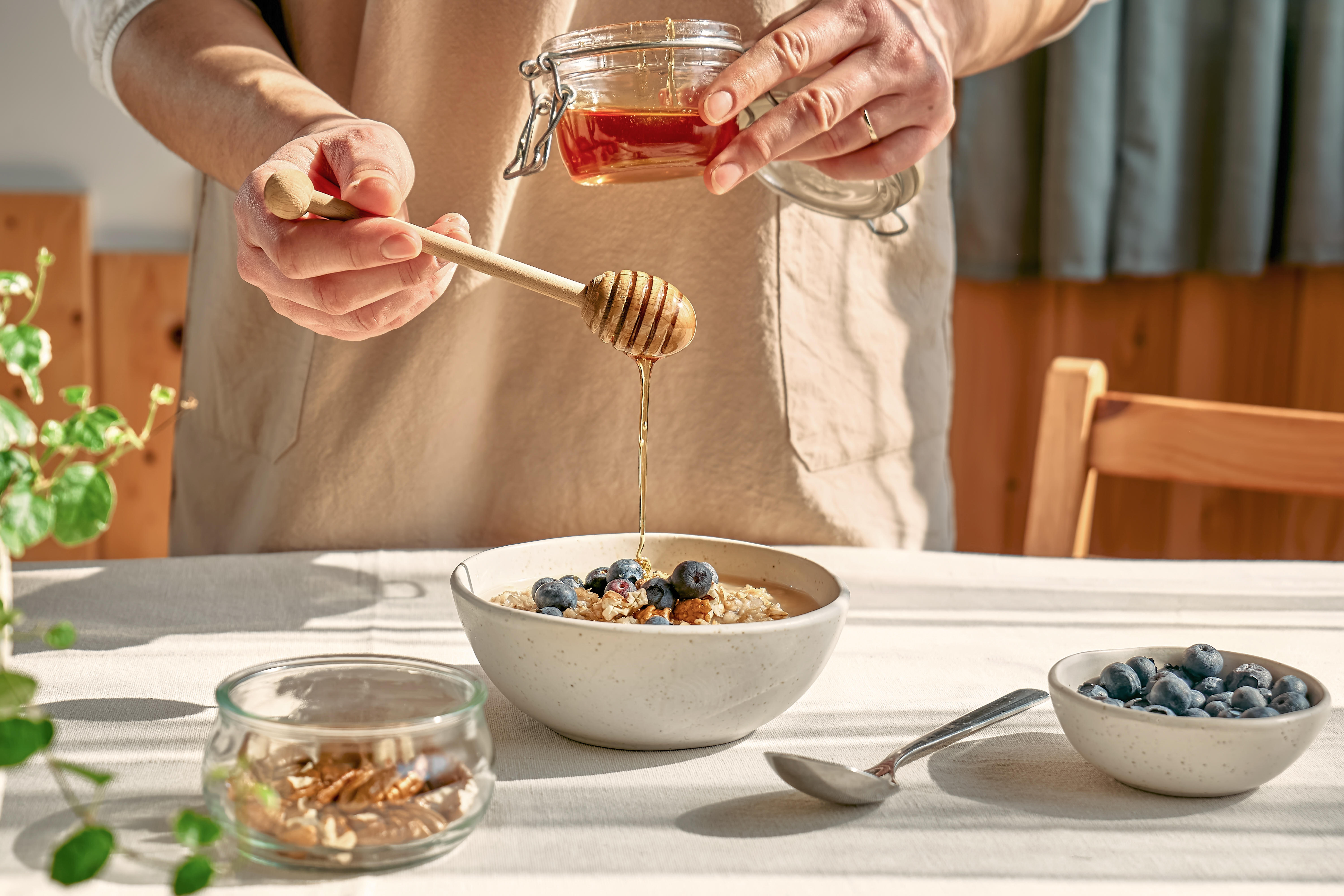 Honey being poured on bowl of fruit and granola