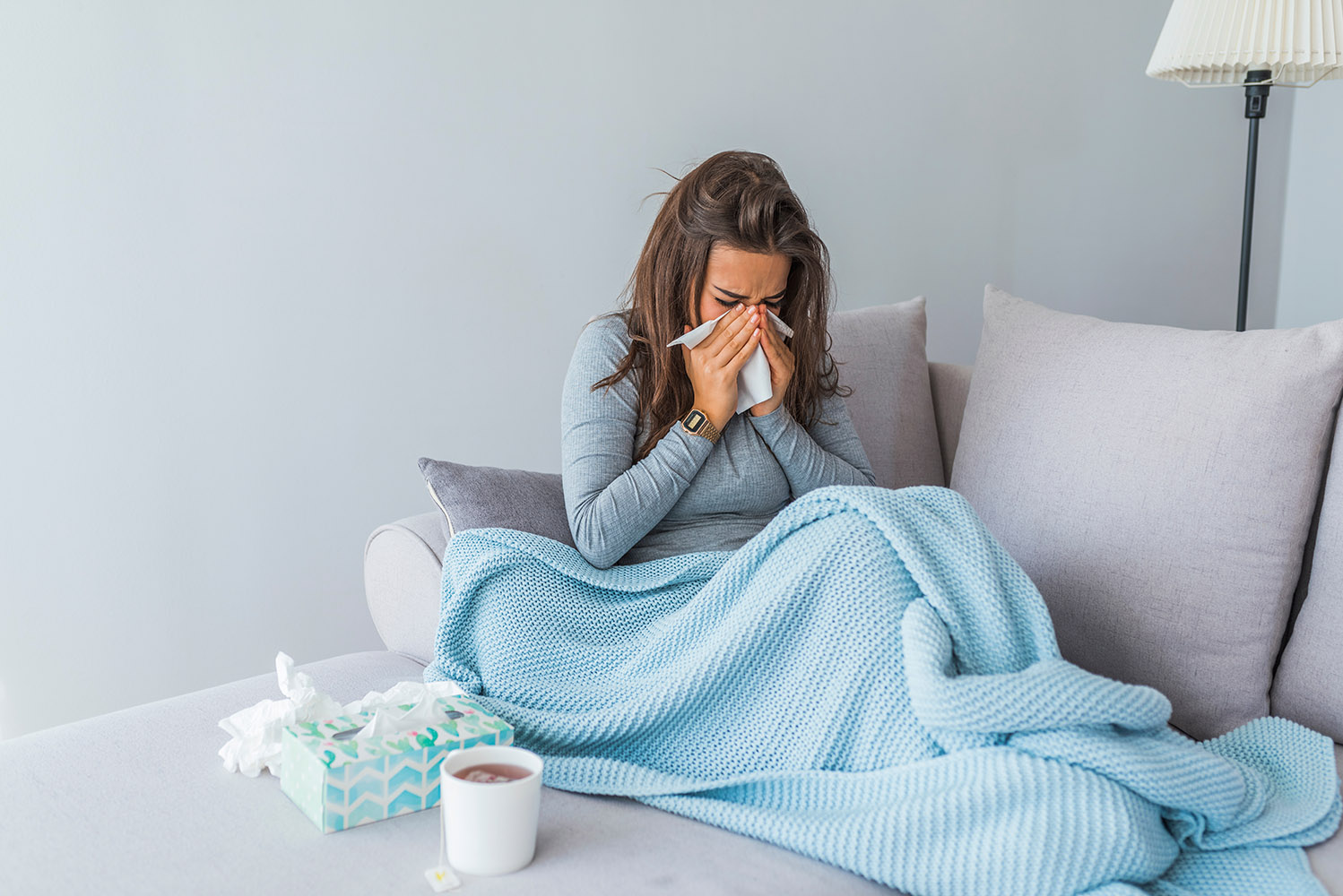 woman sneezing blue