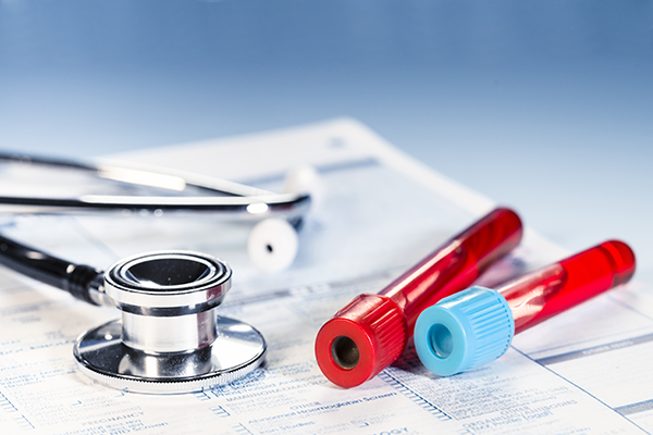 Stethoscope & test tubes on top of documents