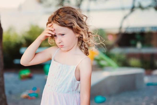 Child holding their head