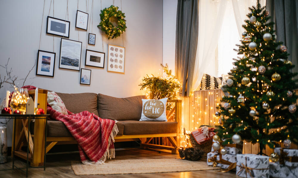 Couronne sur le mur, branches de sapin, guirlandes lumineuse, plaid coloré : une belle ambiance de Noël 
