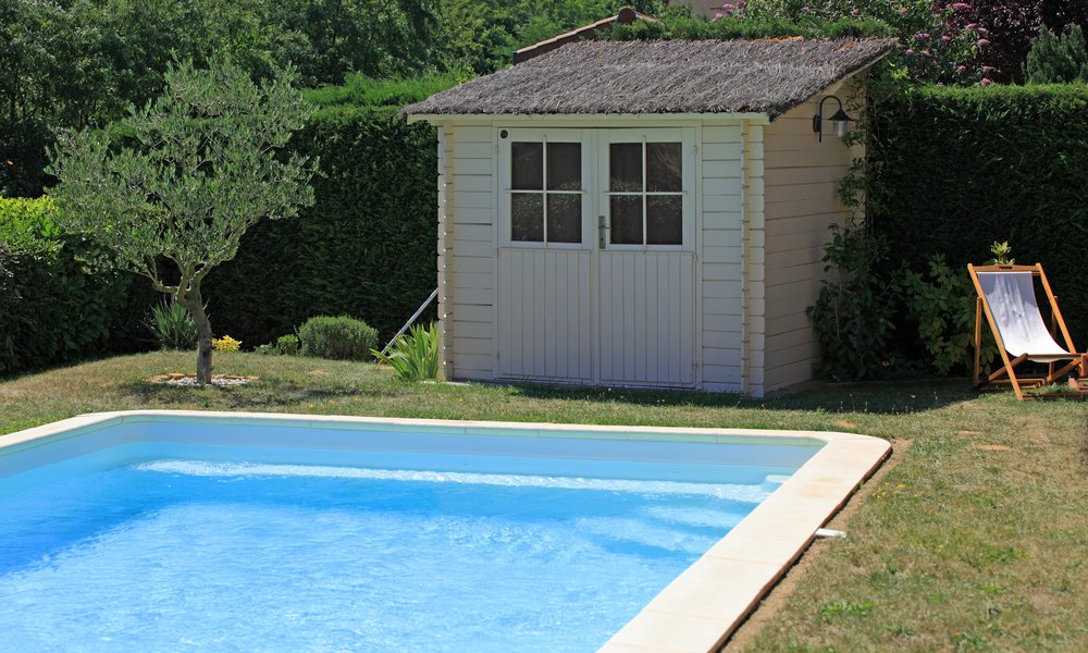 Un abri de jardin en bois s'intègre parfaitement à proximité immédiate de la piscine 