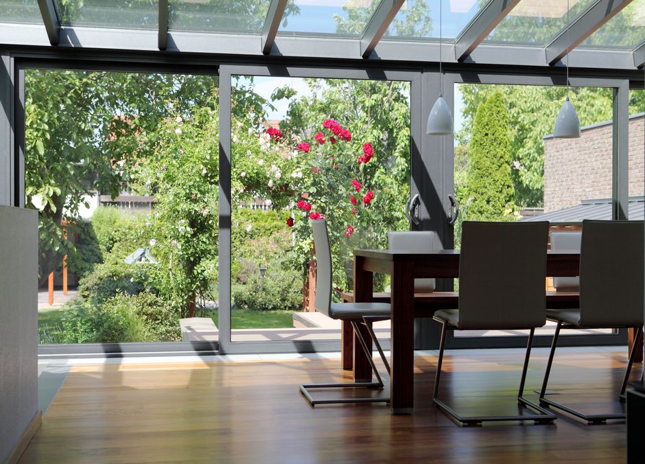 La véranda est ouverte sur le jardin mais pas seulement visuellement, les baies vitrées s’ouvrent en grand