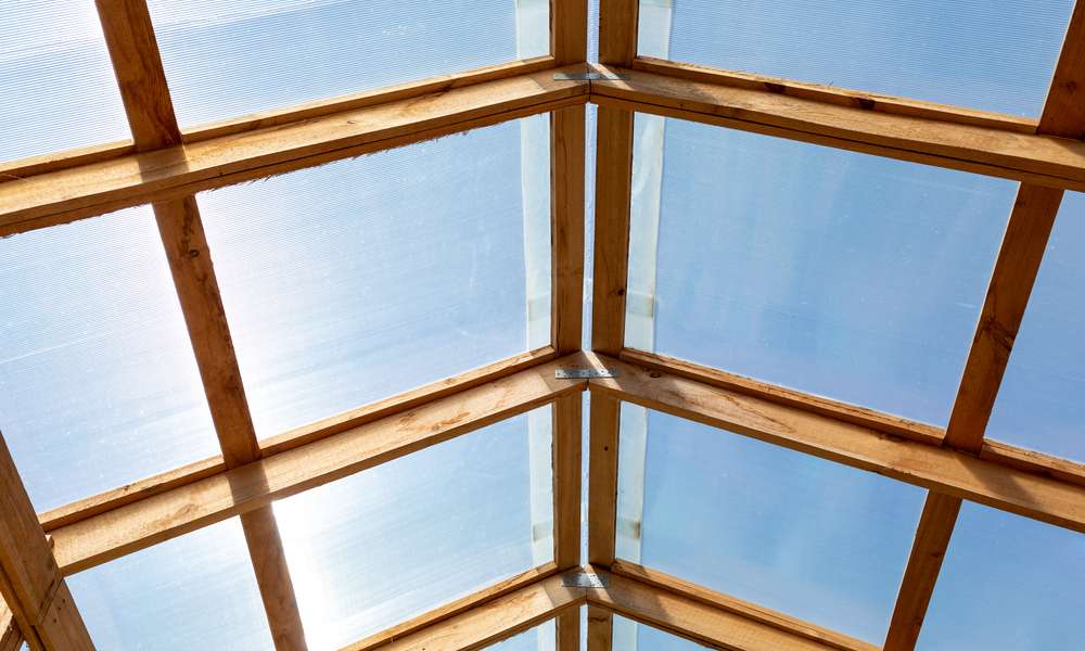 Bois, polycarbonate et grandes ouvertures pour une serre d’agrumes dans le sud 