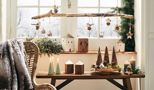 Décoration de table pour Noël avec fagot de bois, houx et pin