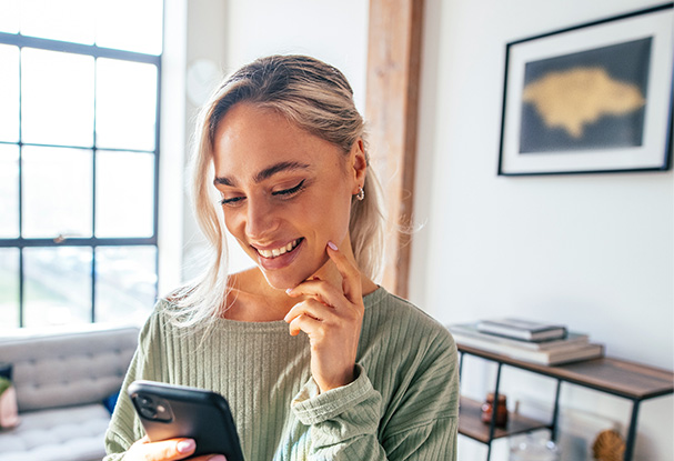 common - Woman looking at phone in the living room