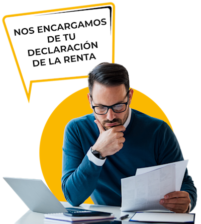A man in a blue sweater and glasses thoughtfully examines a document at a desk with a laptop. A speech bubble reads, Nos encargamos de tu declaración de la renta.
