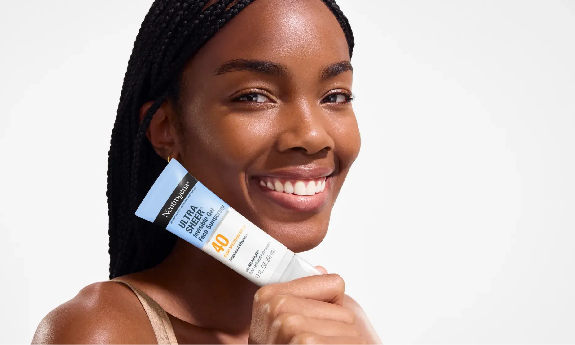 Woman smiling holding Neutrogena Ultra Sheer Invisible Gel Face Sunscreen Broad Spectrum SPF 40, 1.7 Oz