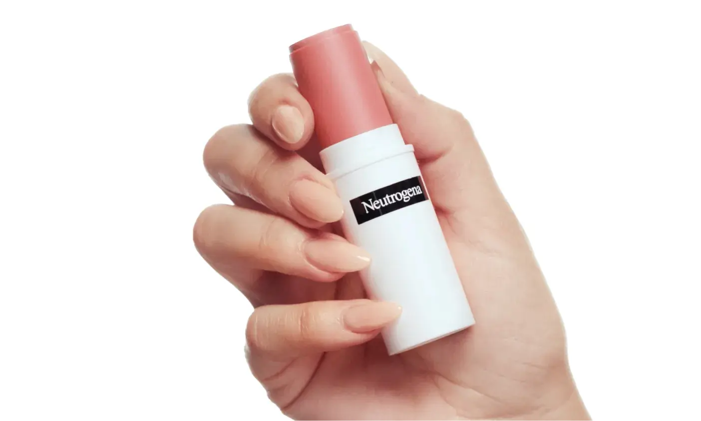 A woman holding a stick of Neutrogena® Healthy Glow Blush Stick Spiced Rose in her hand