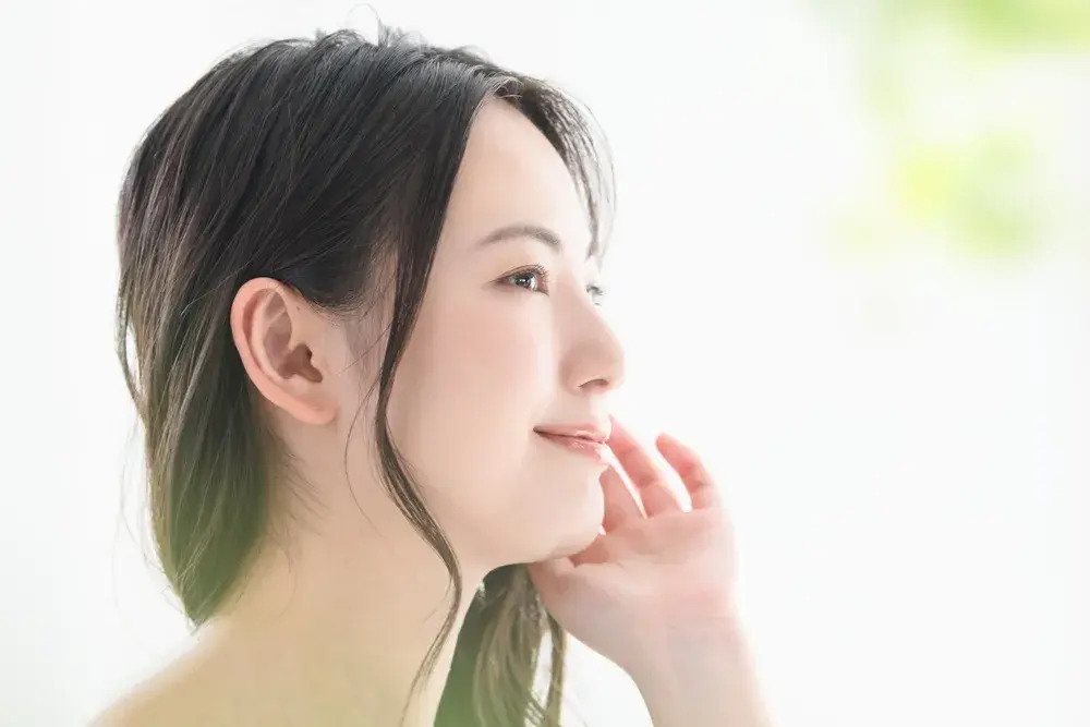 A beautiful woman with a beautiful smile and hands on her face