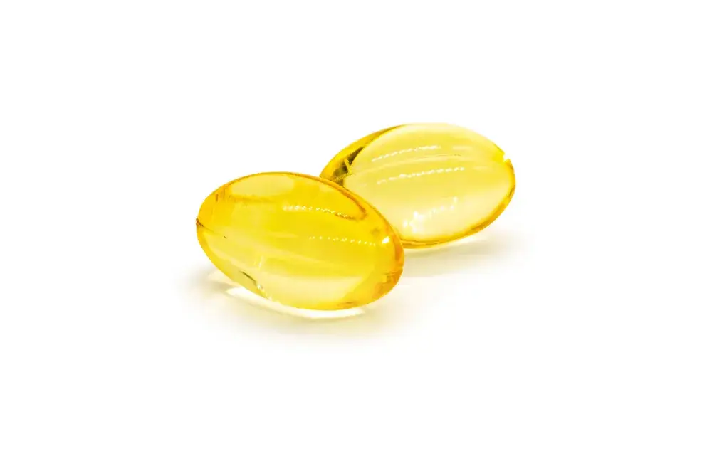 A yellow gel capsule on a white background.