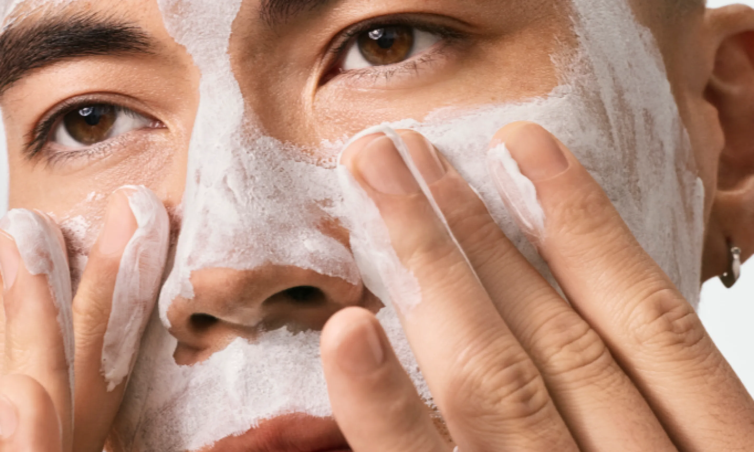 Man applying Neutrogena® Evenly Clear™ Acne Cleansing Mask to face