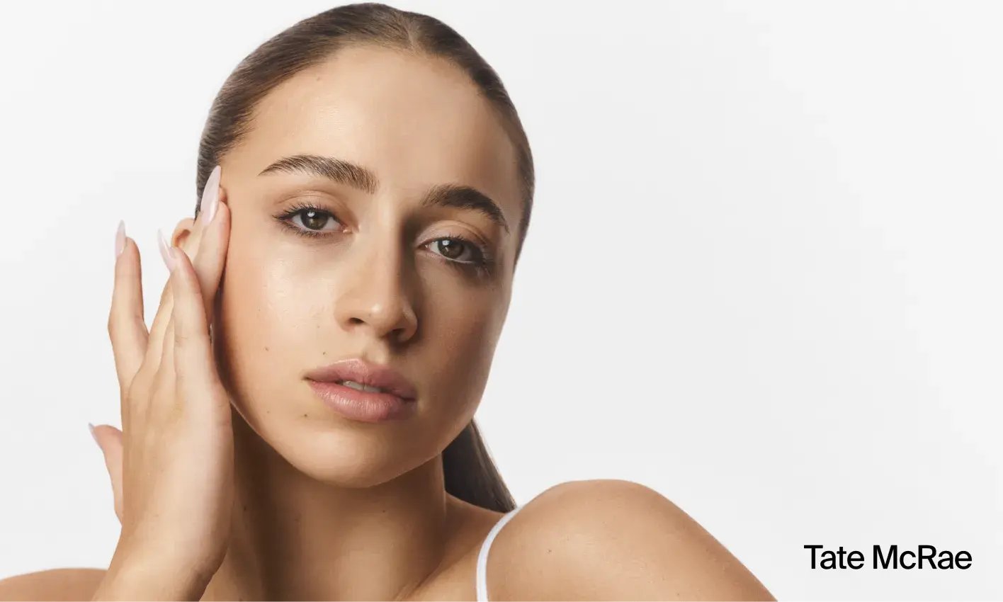 Tate McRae with clear skin applying Neutrogena® Hydro Boost products to face