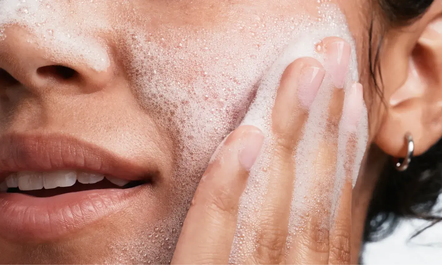 woman applying Neutrogena® Evenly Clear™ Acne Cleanser to face