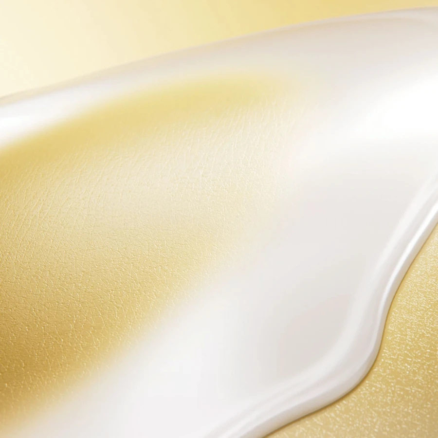  A white, creamy substance is spilled on a textured, golden surface for mobile.