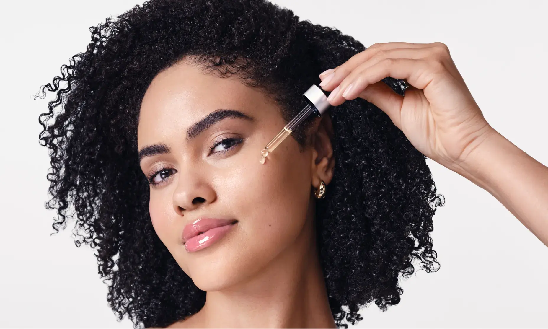 Woman applying Neutrogena® Rapid Wrinkle Repar® Retinol Renewal Serum to face