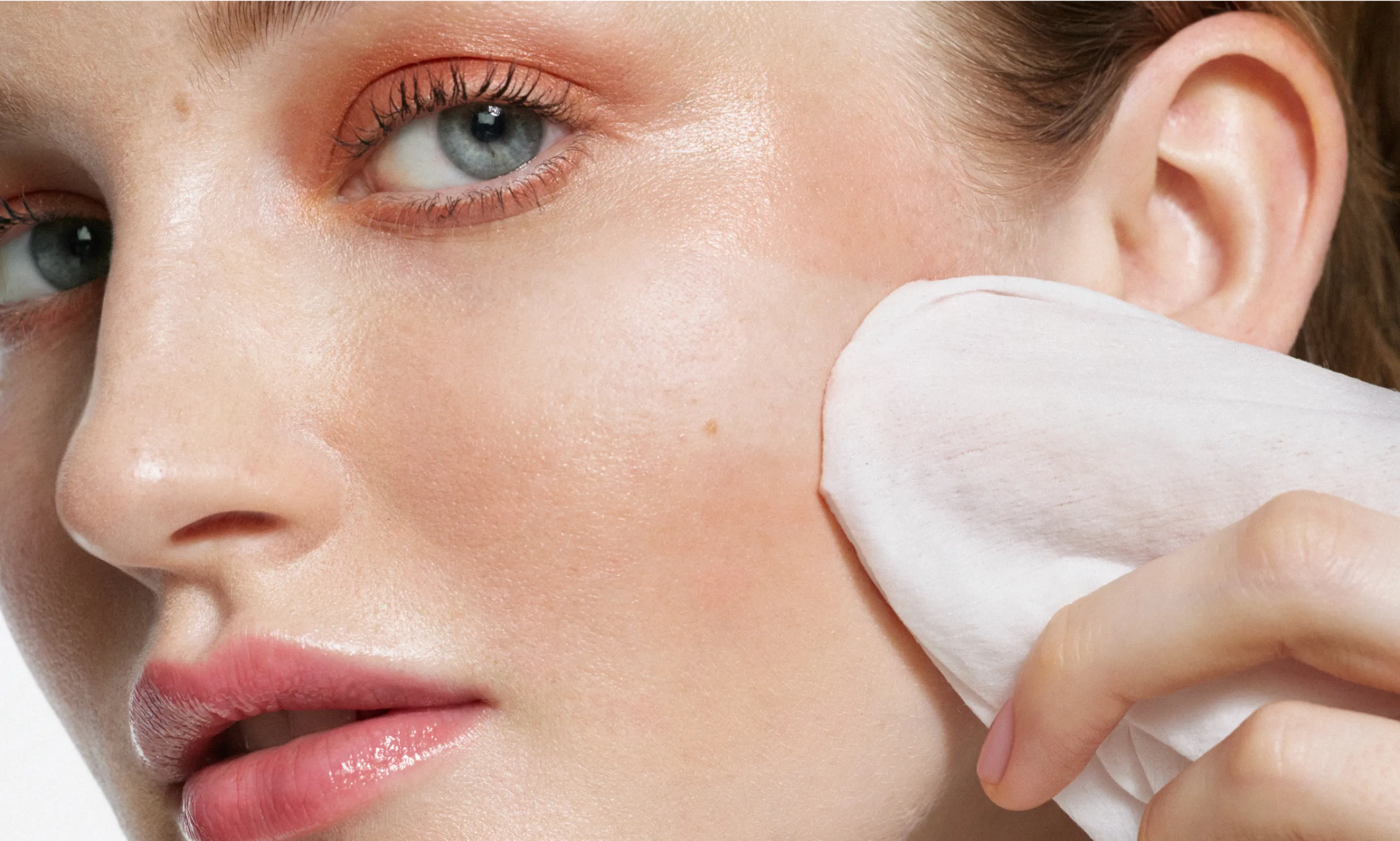 Woman applying wipe to face