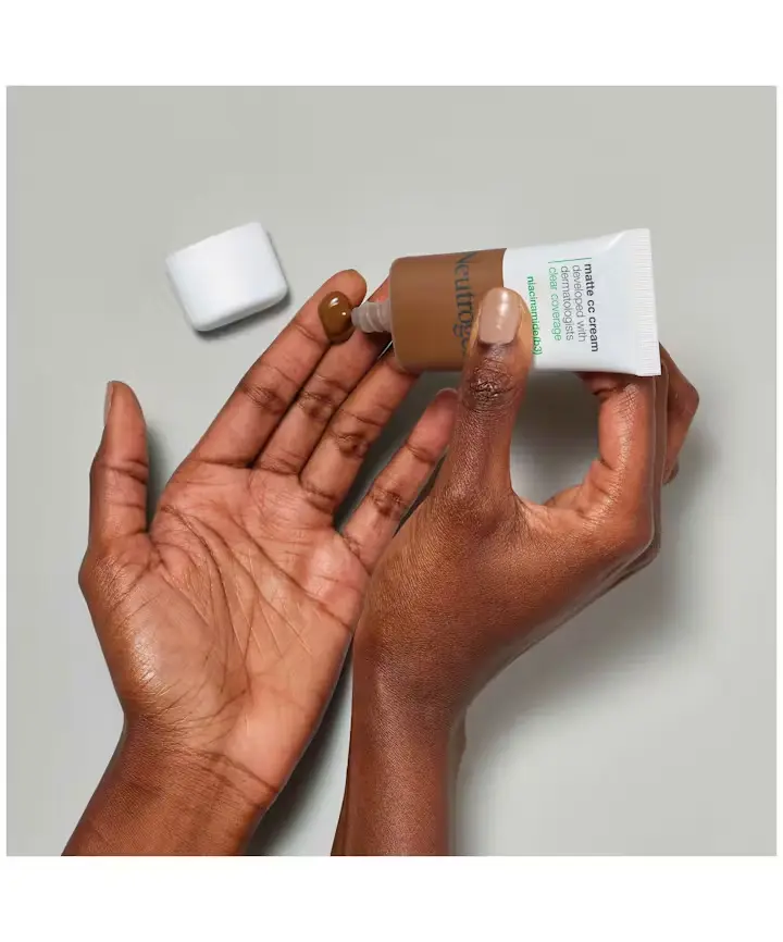 a woman applying Neutrogena® Clear Coverage Flawless Matte CC Cream on her hands