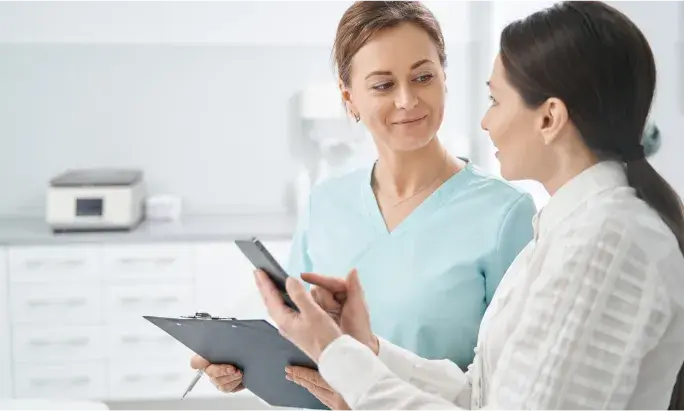 A woman discussion treatments with her dermatologist in an office