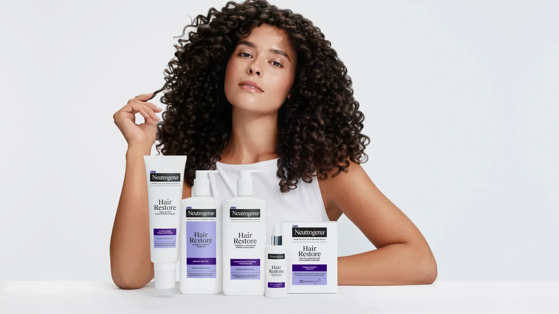 Hero Banner for Neutrogena Hair Restore product line displayed with a model with curly hair.