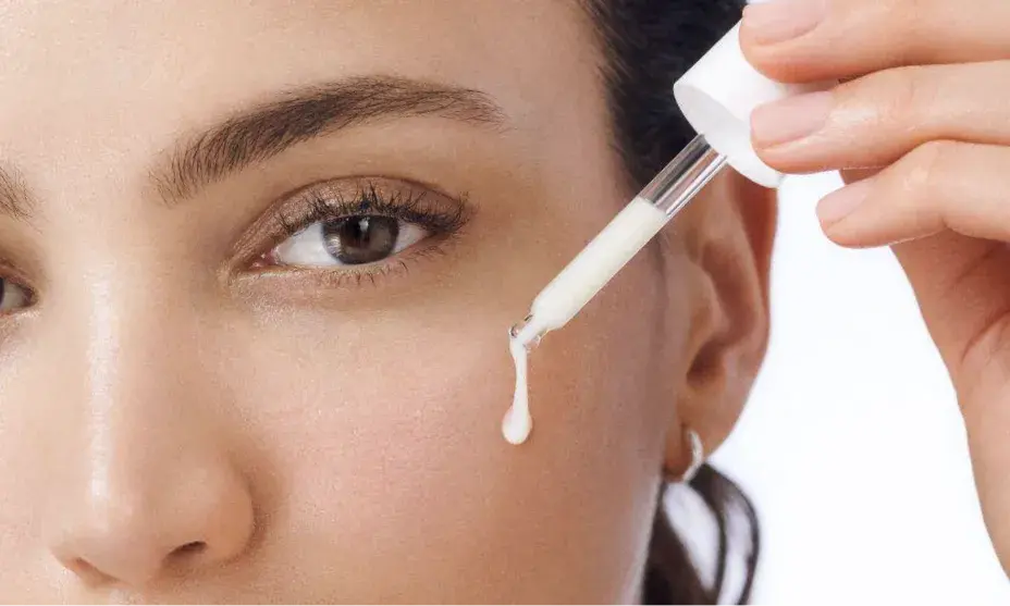 Woman with healthy skin applying dropper full of Rapid Wrinkle Repair® Serum to face