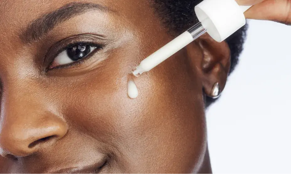 Woman with healthy skin applying dropper full of Rapid Wrinkle Repair® Serum to face