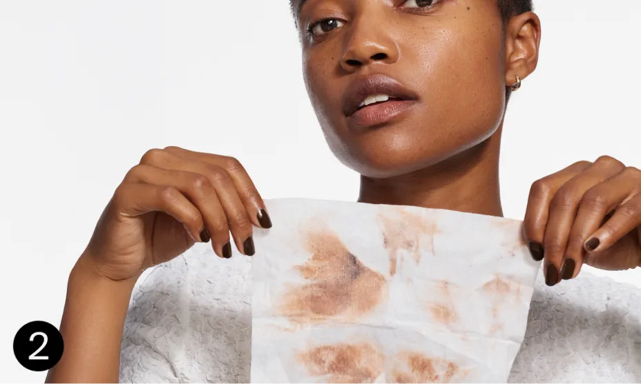 woman displaying wipe after using with makeup off