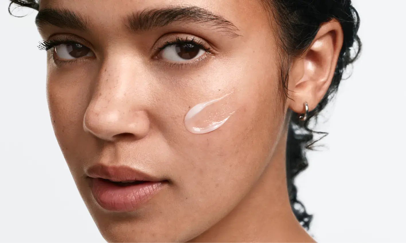 woman applying Neutrogena® Evenly Clear™ Acne Gel Moisturizer to face