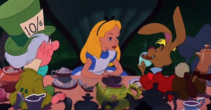 The Mad Hatter, a white man with white hair and a green suit, teal bow tie, and a giant green top hat with a 10/6 size tag tucked into the brim, sits at a table covered in teapots and teacups, facing away from the camera.  Next to him, also facing away, is the Dormouse, a little brown mouse who sits in a green teapot.  Across the table from them is Alice, a white, blonde girl with a black hairband with a bow, and a blue dress with a white pinafore.  The March Hare, a brown rabbit with a bit of blond hair wearing a red shirt, brown pants, and a red bow tie, is laying on the table on his stomach, drinking a cup of tea with his eyes closed, talking to Alice.