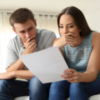 Worried couple looking at document Thumb