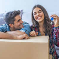 happy couple with packing box and door key thumb